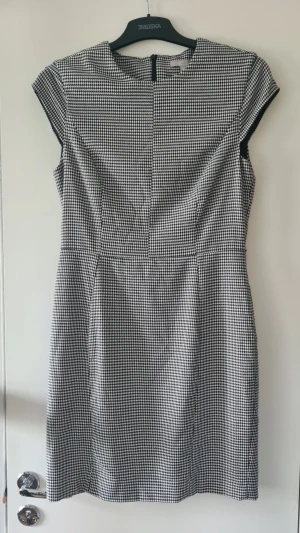 H&M - Figurnära klänning med hundtandsmönster. Går ned till knäna.