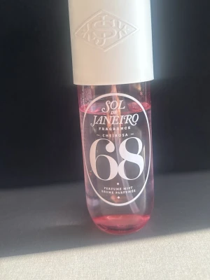 Sol de Janeiro Cheirosa 68 Perfume Mist - Sol de Janeiro Cheirosa 68 Perfume Mist i en genomskinlig rosa plastflaska med vit kork. Flaskan har en modern design och tydlig logga framtill. Perfekt för dig som gillar fräscha och tropiska dofter.