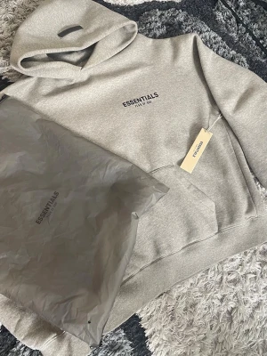 Essentials Fear of God hoodie - Grå - Säljer denna bekväma och stilrena hoodie från Essentials i en klassisk grå färg kommer med tillhörande påse och märkning, onlinekvitto vilket garanterar äkthet. Skickar paketet inom 24H📦 Storlek XS passar som S  