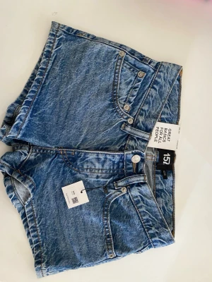 Mörkblå shorts - Mörkblå deminshorts med fickor både fram och bak. Med detaljer på fickorna där bak. Helt nya och aldrig använda.