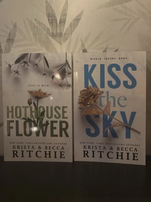 Hothouse Flower & Kiss the Sky - Två skönlitterära böcker: 'Hothouse Flower' med grön text och blomillustration samt 'Kiss the Sky' med blå text och torkad blomma på omslaget. Båda är engelskspråkiga pocketböcker av Krista & Becca Ritchie.