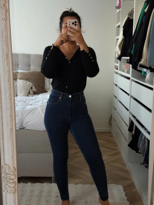 Mörkblå high waist skinny jeans - Säljer ett par mörkblå skinny jeans med hög midja och klassiska fickor fram och bak. Jeansen har en tight passform och är perfekta för dig som gillar en stilren look. Materialet är stretchigt och bekvämt.