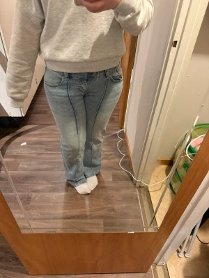 Ljusblå bootcut jeans från lager 157 - Säljer ett par ljusblå bootcut jeans från lager 157 med klassisk femficksmodell och markerad söm framtill. Jeansen har låg midja och är tillverkade i mjuk denim med lite stretch för skön passform. Perfekta till sneakers eller boots.