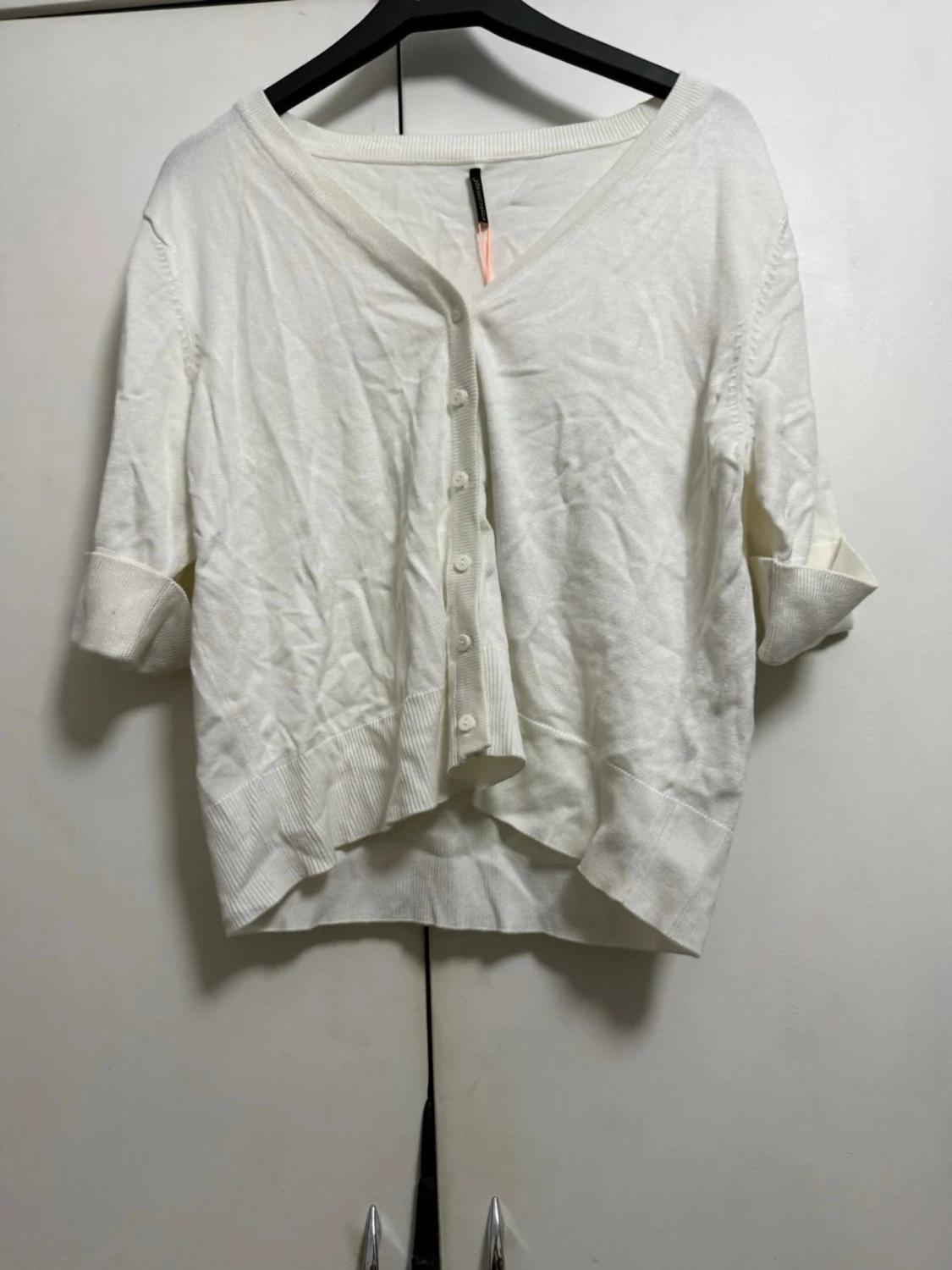 Vit kofta med knappar och v-ringning