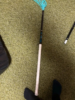 Innebandyklubba med turkost blad - Säljer en innebandyklubba med svart skaft och turkost plastblad. Greppet är lindat med vitt greppband. Klubban har en sportig look och är perfekt för dig som gillar innebandy. Märket är M-X och materialet är en kombination av plast och komposit. Ny
