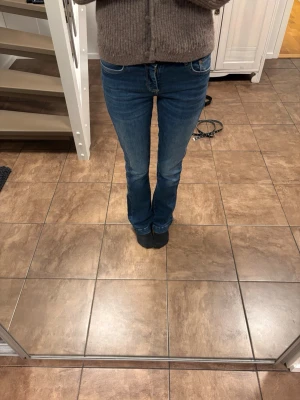 Blå bootcut jeans med stretch - Säljer ett par klassiska blå bootcut jeans med normal midja (midwaist) och lätt utsvängda ben. Köpta från zalando men är från märket LTB i modellen Fallon. Storlek 26/32. Midjemått tvärs över ca 35 cm men är lite strechig. Innerbenslängd 80 cm. Passar bra i längden på mig som är 170 cm. Små slitningar längst ner på benen baktill. Nypris 799 på zalando. Bara att höra av sig vid frågor🤗