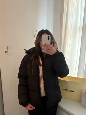 Svart pufferjacka från Polo Ralph Lauren - Säljer en svart pufferjacka från Polo Ralph Lauren med klassisk röd logga på bröstet. Skulle säga att jacka är unisex i storlek M. Köpte jackan för ca 1 månad sedan och bara använd några fåtal gånger. Jackan är i väldigt fint skick inga defekter. Pris kan diskuteras vid snabb affär!
