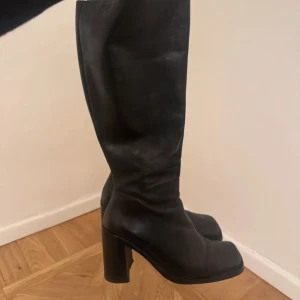 Svarta höga läderstövlar med klack - Säljer ett par Björn Borg svarta boots i äkta läder med chunky klack och fyrkantig tå. . Perfekta för dig som vill ha ett par boots med attityd och höjd! Sååå snygga och bekväma! Dragkedjorna har gått av men klackarna går fortfarande att stänga ordentligt det är bara pluppen man tar i som saknas