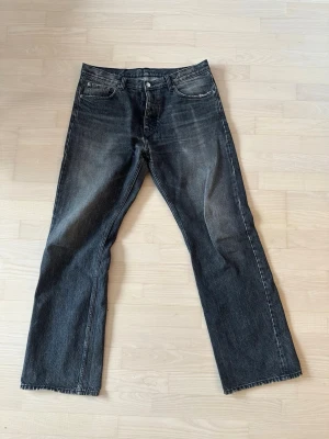 Gråa HOPE jeans med raka ben - Säljer ett par gråa hope jeans med raka ben och lätt slitna detaljer. Jeansen har klassisk femficksmodell, knappgylf och är tillverkade i denim. Perfekta för en avslappnad och trendig look.  Jag är 190cm och har långa ben, de sitter bra på mig. 