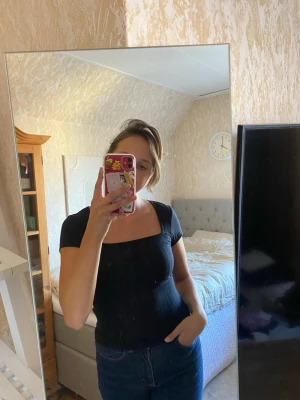 Svart ribbad topp  - Svart ribbad topp med urringning, i storlek xsmall men passar även small