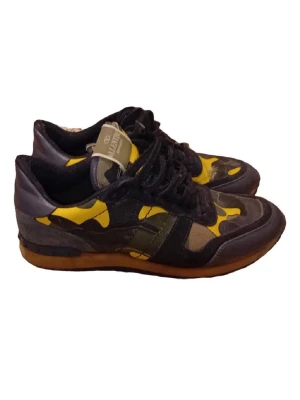 Valentino camo sneakers svart/gul - Säljer ett par snygga sneakers från Valentino med svart och gul camo-mönster. Skorna har svarta snören, gummisula och detaljer i mocka och läder. Perfekta för dig som vill sticka ut med en unik och trendig look.