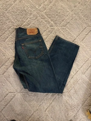 Levi's blå raka jeans - Säljer ett par klassiska blå jeans från Levi's med rak passform och femficksdesign. Mått syns finns i bilderna. 