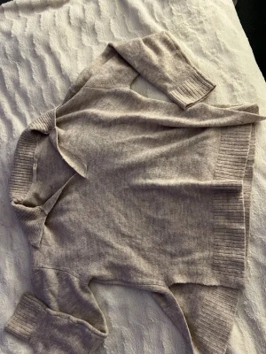 Beige stickad tröja med krage - Mysig beige stickad tröja med bred ribbstickad mudd vid ärmslut och nederkant. Tröjan har en avslappnad passform och en snygg krage som ger en chill vibe. Perfekt för lager-på-lager och passar till allt. Storlek xs men skulle säga att den passar på M 