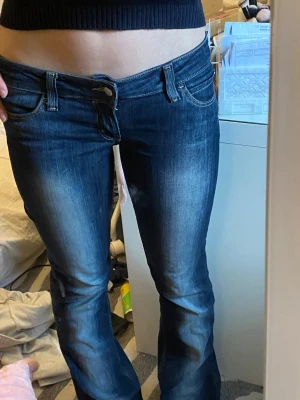 Mörkblå bootcut kvarg  jeans weekday - Säljer ett par mörkblå kvarg jeans med bootcut-modell. Jeansen har låg midja, klassiska fyra fickor. Jeansen är i helt nytt sick med inga slitningar alls andvänd fåtal gånger. Bra för lång person då dem är 31/34. Mått:innerbenslängd:87 cm, midja rakt över 42.