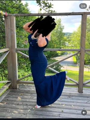 Marinblå offshoulder långklänning - Hej! Nu börjar balen snart närma sig för många och tänkte sälja min balklänning som jag hade i 9ans bal! Det är en lång marinblå off shoulder klänning med lite glittrigt på, med öppen rygg. Använts 1 gång och hänger nu bara i garderoben. Den har en stripe på insidan ovanför bröstet så den inte åker ner. Jag dansade och hoppade hela kvällen och den rörde sig inte. Storlek: EUR 42