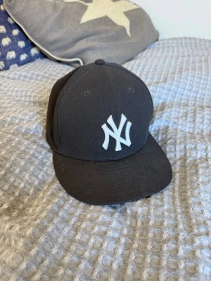 New era keps - Säljer denna sjukt snygga Yankees keps i storleken 7, 1/8 som är 56,8 cm. Den är i ett väldigt bra skick och inte använd särskilt mycket. Färgen är mörk grå.