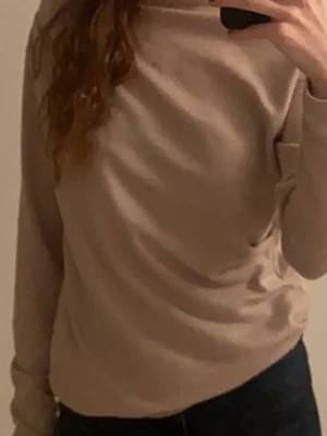 Beige basic tröja med lång ärm - En enkel beige/ljusrosa tröja med långa ärmar och rund hals. Materialet ser mjukt och bekvämt ut, perfekt för lager på lager under kyligare dagar.