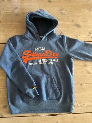 Superdry Hoodie - Nu säljer jag en snygg blå hoodie från Superdry. Hoodien är i storlek M och har en normal passform. En vintage tröja som är mycket trendig och perfekt för våren. Hör av er vid frågor!☀️
