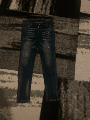 Mörkblå DSQUARED2 jeans Storlek xs,s - Säljer DSQUARED2 för tar inte på mig de längre. Jätte sköna och fräscha. Men det finns ett litet hål i högra fickan men det går att sy den.