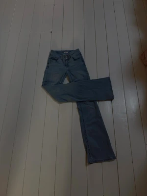 Ljusblå bootcut jeans från Nelly - Säljer ett par ljusblå bootcut jeans från Nelly. Jeansen har klassisk femficksdesign, broderad detalj på bakfickan och är tillverkade i mjuk bomullsdenim. Snygg passform med något utsvängda ben och låg midja.