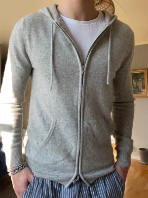 John Henric Kashmir Zip Hoodie Grå – Strl M – Nyskick - Säljer en exklusiv John Henric zip hoodie i kashmirblandning i grå färg. Mycket mjuk och bekväm med stilren passform. Använd sparsamt och i nyskick.  • Storlek: M • Färg: Grå • Skick: Nyskick • Nypris: ca 3299 kr  Perfekt både till vardag och mer uppklädda outfits.