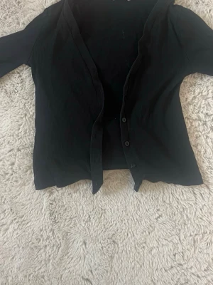 Svart kofta - Använd i bra skick! Den är ganska kort och uringad, fint att ha ett linne under. 