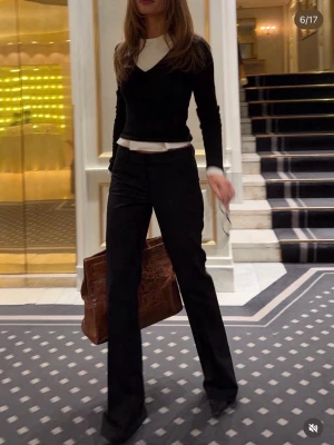 Svarta utsvängda byxor - Snygga svarta byxor med utsvängda ben och medelhög midja. Perfekta för en trendig och stilren look. Matcha med en croppad topp eller stickad tröja för en modern vibe. Storlek L men passar M