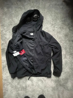 Cp company jacka  - Äkta cp company jacka! Köpt ifrån cp companys hemsida och har verifierats med (GLC code) nypris på denna ligger runt 5000:- men mitt pris är 2099 men kan lätt tänka mig kanske gå ner lite! OBS! qr koden har slutat fungera alltså att den inte går att scanna längre de funkade innan men vet inte om ja råkat dra den emot något eller så men den har slutats fungera ellefall darför ja checka GLC koden!! Hör av er vid intresse mvh!