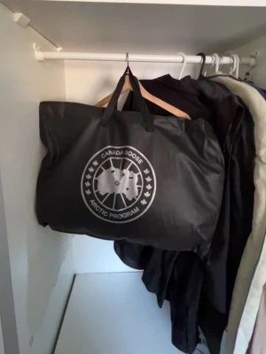 Svart dunjacka från Canada Goose - Säljer en exklusiv Canada Goose Black Label dunjacka i svart med päls.  • Storlek: XXL (passar mer som XL) • Modell: Kort bombermodell med huva och äkta päls • Färg: Svart (Black Badge – diskret logga) • Skick: Nyskick, aldrig använd • Komplett: Päls, alla originaldelar kvar • Äkthet: QR-kod finns och verifierar direkt på Canada Goose hemsida  En mycket varm och stilren premiumjacka från Canada Goose. Black Label-serien har en mer exklusiv och nedtonad design jämfört med standardmodellerna.  