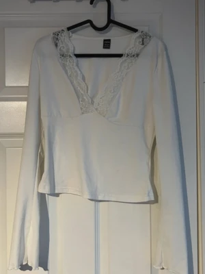 Vit spets topp  - Säljer en vit långärmad topp med djup V-ringning och vackra spetsdetaljer. En romantisk och feminin topp som passar perfekt för dig som gillar enkla plagg med fina detaljer.(ifrån shein)