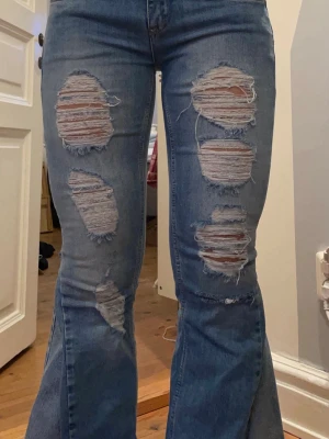 Lågmidjade jeans med slitningar  - Säljer dessa lågmidjade jeans med slitningar på benen. Jeansen är omsydda till bootcut och midjemått 37 cm innerbenslängd 73 cm. Kontakta mig gärna privat vid frågor eller liknande 💕💕