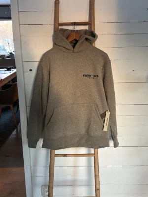 Grå Essentials Fear of God hoodie - Snygg grå hoodie från Essentials Fear of God. Storlek xs 