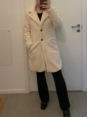 Fuskpäls viLiosi Teddy Coat - Säljer en lång, krämvit teddyjacka med två stora knappar framtill. Är 158 och längden är perfekt på mig. Använd max 2-3 så den är i mycket bra skick!