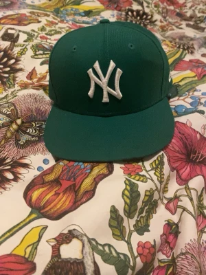 Grön New Era Yankees keps - Snygg grön keps från New Era med klassisk New York Yankees-logga broderad i vitt framtill. Storlek 7/ 55.8 cm 