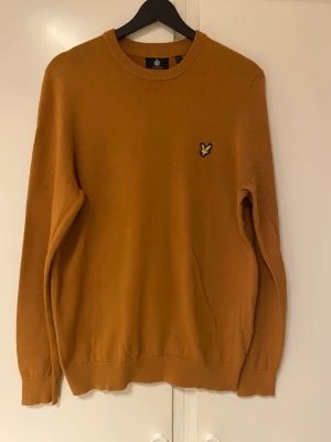 Brun tröja från Lyle & Scott - Brun rundhalsad tröja från Lyle & Scott med den klassiska broderade loggan på bröstet. Den är i gott skick.
