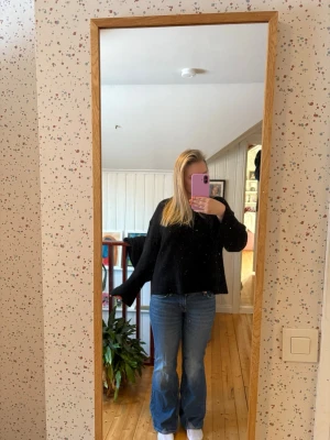 Blå bootcut jeans med låg midja - Säljer ett par klassiska blå bootcut jeans med lpg midja och lätt utsvängda ben. Jeansen har en tidlös tvätt och sitter snyggt över höfterna. Perfekta till sneakers eller boots. Materialet är denim i bomull.