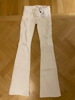Vita bootcut jeans med snörning - Populära vita lågmidjade bootcut jeans från gina 14+! Helt slutsålda överallt. Helt oanvända med prislappen kvar eftersom jag råka beställa fel storlek☺️