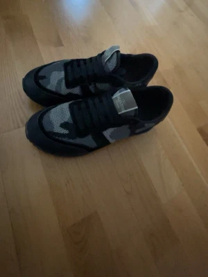 Svarta och grå kamouflage sneakers - Säljer ett par valentino rockrunners. Str 43 knappt använda. Box kommer ej med. Pris kan diskuteras!!!