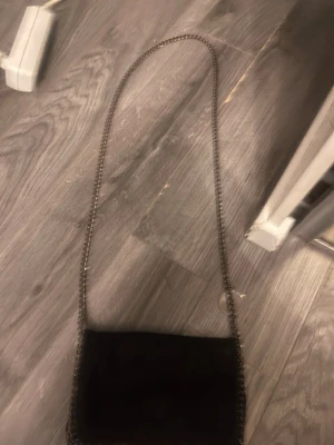 Svart axelväska med kedjerem - Stella mcarntney dupe köpt i Malmö för cirka 500kr kommer inte ihåg vart ifrån dock. Inte använd på länge men använt ett par gånger.