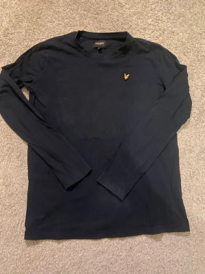 Lyle & Scott tröja marinblå - Säljer nu denna långärmade blåa t-shriten från Lyle & Scott eftersom jag har växt ur den skicket är 8/10 storleken är 12/13 år och nypris är runt 500kr. Om ni har några frågor är det bara att skriva!!