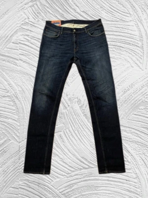 Acne Studio Jeans - (W36/L34) Säljer ett par mörkblå jeans från Acne Studio med rak passform och klassisk femficksdesign.  Materialet är denim i bomull och de har en läderpatch bak i midjan där det står ”Acne Studios”. Perfekta för en avslappnad och stilren look.
