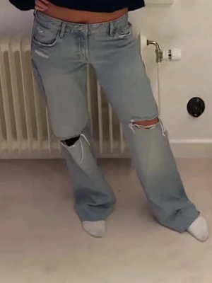 Zara ljusblå ripped jeans med raka ben - Säljer ett par ljusblå jeans med raka ben och slitna detaljer över knäna. Jeansen har klassisk femficksmodell, låg midja och en avslappnad passform. Använt dom en gång❤️❤️
