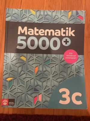 Matematik 5000+ 3c kursbok - Matematik 5000+ 3c är en kursbok för gymnasiet, anpassad efter den reviderade ämnesplanen 2021. Boken har ett blått geometriskt mönster på omslaget och innehåller programmering, problemlösning och digitala verktyg. Perfekt för dig som läser matematik på hög nivå.