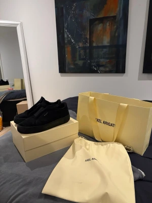  Axel Arigato skor  - Stilrena svarta sneakers från Axel Arigato . Klassisk modell med svart sula. Skorna levereras med originalpåse och låda. Skick 9/10.