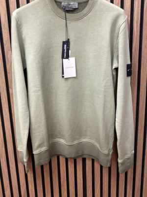 Ljusgrön sweatshirt  - Snygg ljusgrön sweatshirt från med klassisk rund halsringning och ribbade muddar. Tröjan har den ikoniska logotypen på vänster ärm och är tillverkad i mjuk bomull. Perfekt för en avslappnad och trendig stil.