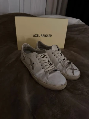 Axel Arigato skor - Använda skor från Axel Arigato, bra skick. Har tvättat och använt skofärg för att fräscha upp dem. Färgen syns lite extra på vissa ställen men det syns inte vid användning