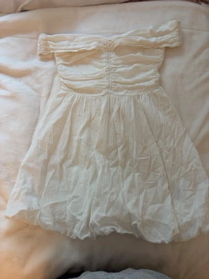 Vit klänning  - Vit klänning från hm. Off-shoulder med fin puffig ballongkjol. Skulle säga att den är lite mindre i storleken