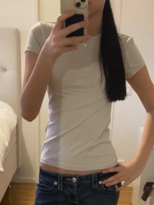 Beige basic t-shirt i bomull - En enkel och stilren beige t-shirt med korta ärmar och rund hals. Tillverkad i mjuk bomull för en skön känsla och perfekt passform. Perfekt att matcha med jeans eller kjol för en clean look.