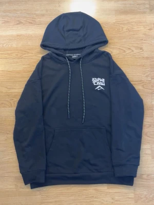 Nike Trail hoodie - Säljer en svart hoodie från Nike Trail med vit logga och bergmotiv på bröstet samt stort tryck med berg och Nike Swoosh på ryggen. Hoodien har huva med dragsko och en stor magficka. Perfekt för dig som gillar streetwear och outdoor-vibe. Det är strl L men den sitter som en M, säljer för att den är för liten för mig och aldrig använts!😊