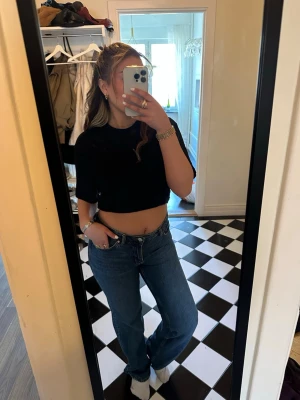 Blå raka jeans med hög midja - Säljer ett par klassiska blå jeans med rak passform och hög midja. Jeansen har fem fickor, bälteshällor och stängs med knapp och dragkedja. Perfekta till en avslappnad look och passar till det mesta. Materialet är denim i bomull.